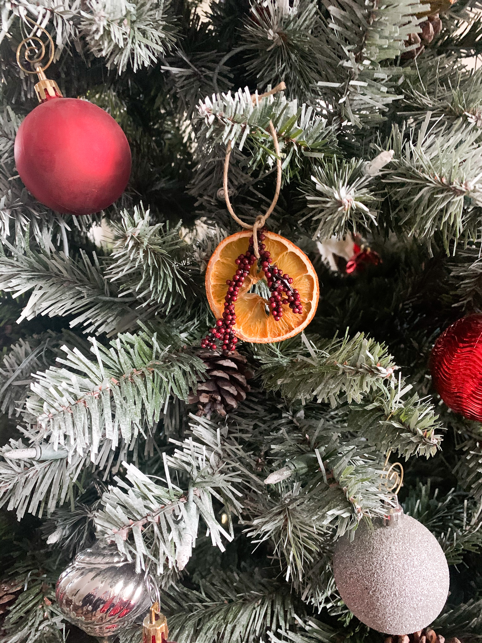 diy dried orange ornament hanging on the christmas tree