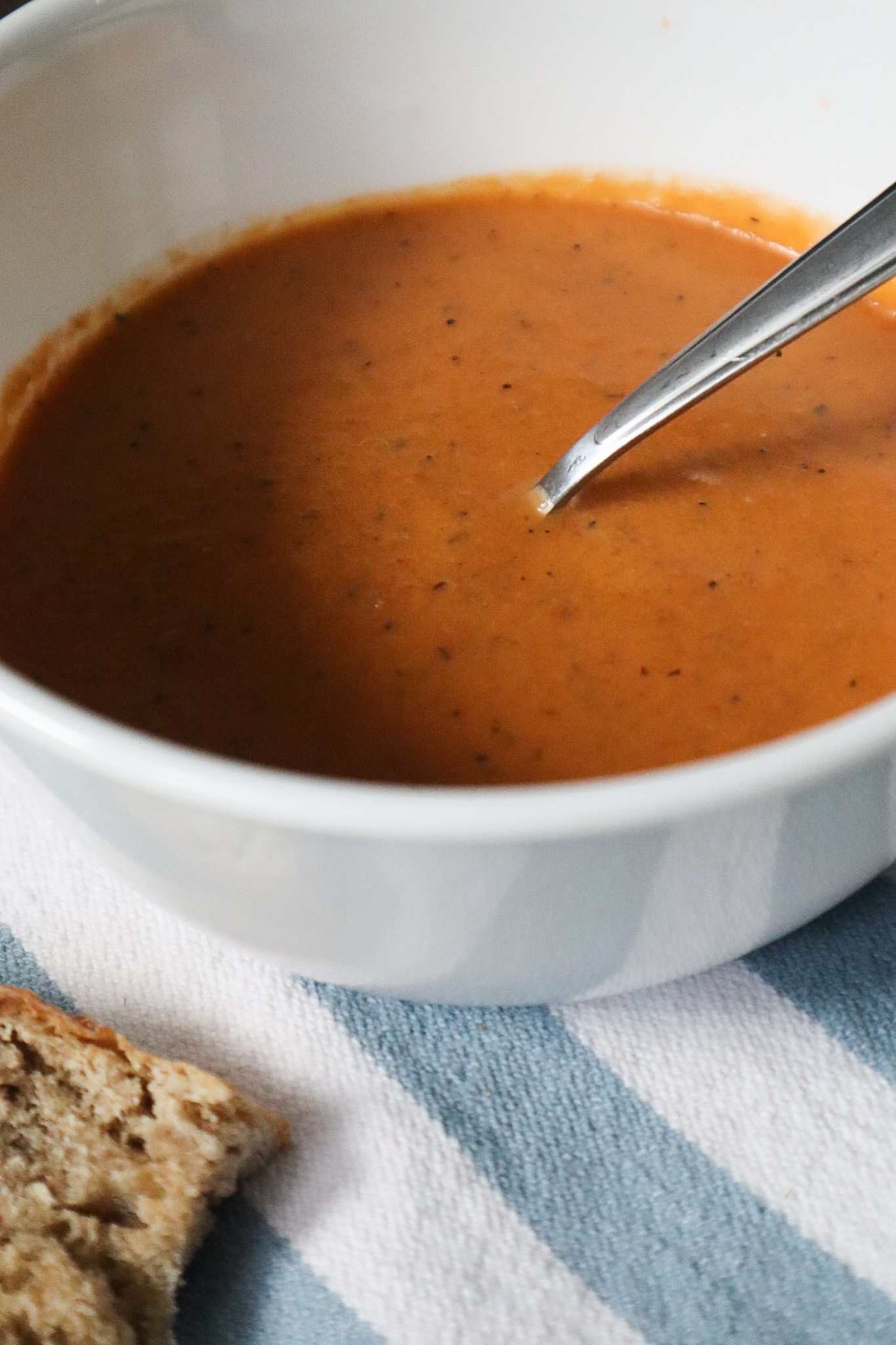 up close picture of the tomato soup in a white bowl 